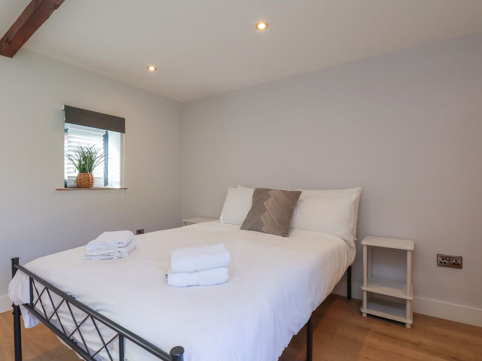A bedroom with a bed and plant on a table at Manor Cottage in Harpham near Nafferton