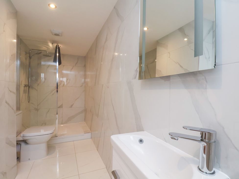 A bathroom with a shower, toilet, and sink at Manor Cottage, Harpham near Nafferton