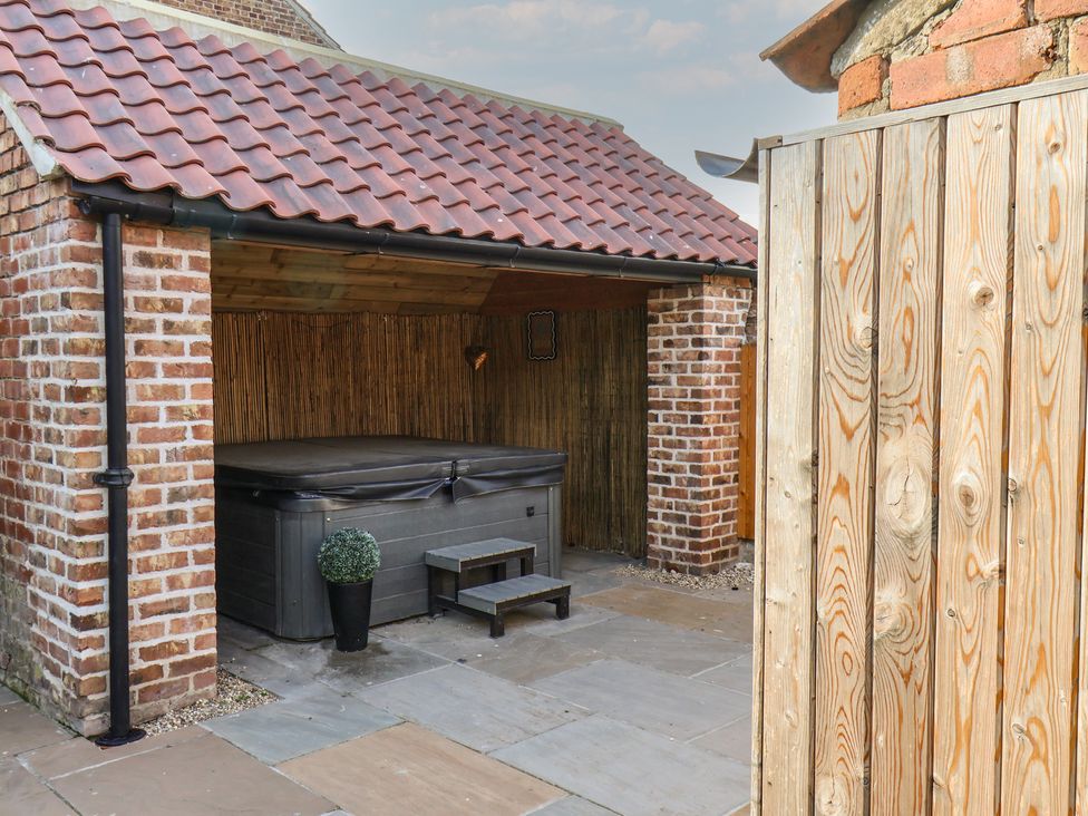 A hot tub with a step and a plant pot at Manor Cottage in Harpham near Nafferton