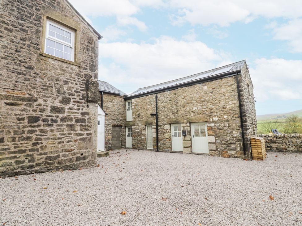 An outdoor area with stone buildings and gravel at Henside Cottage in Settle