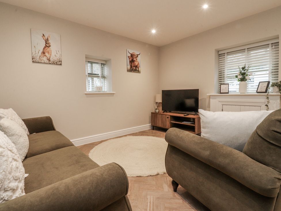 A living room with a sofa and television at Henside Cottage Settle