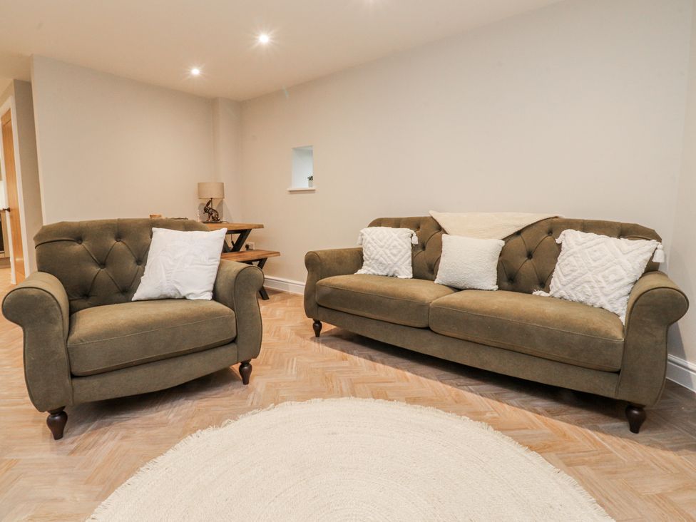 A living room with two sofas and a lamp at Henside Cottage Settle