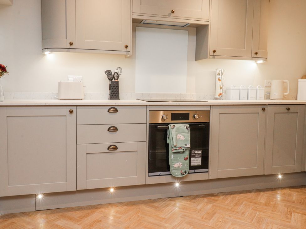 A kitchen with cabinets and an oven at Henside Cottage Settle