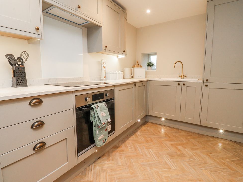 A kitchen with cabinets and appliances at Henside Cottage Settle