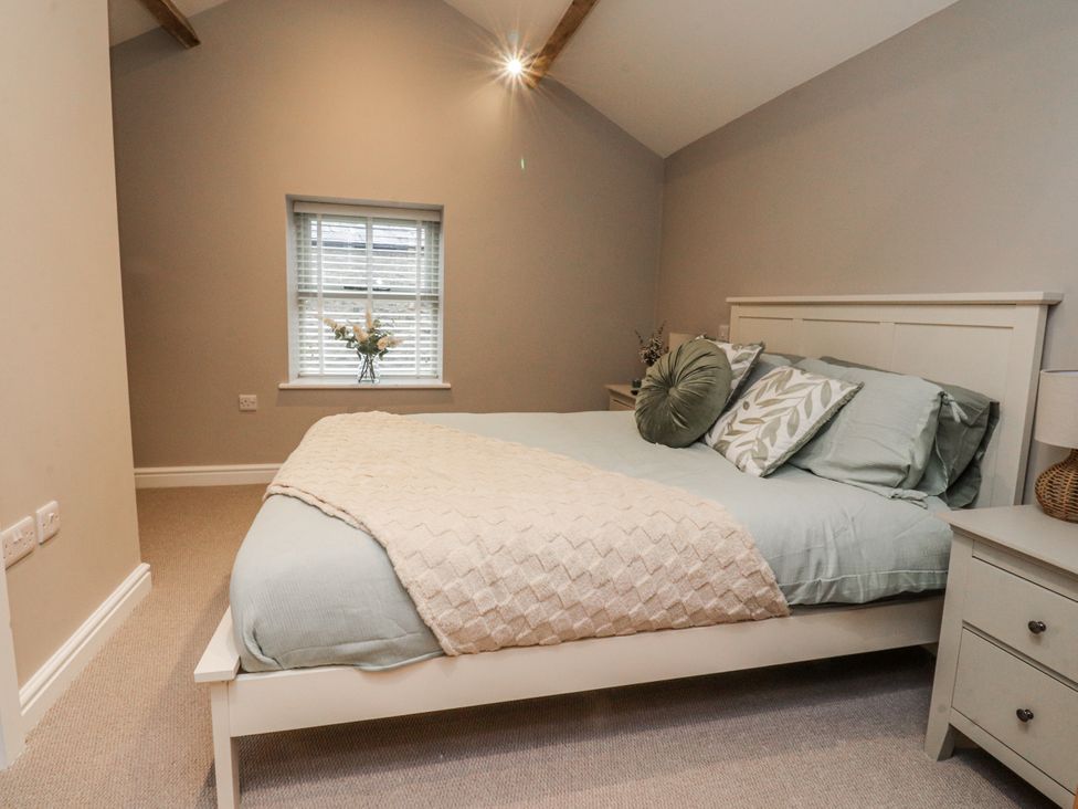 A bedroom with a bed and nightstand at Henside Cottage Settle