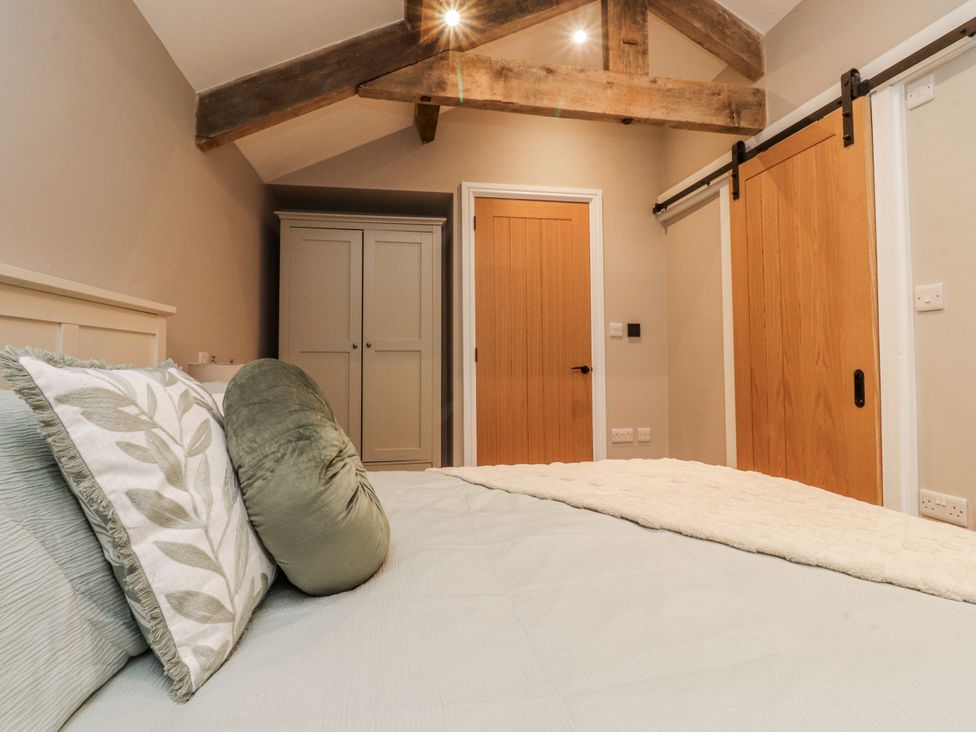 A bedroom with a bed and wardrobe at Henside Cottage Settle