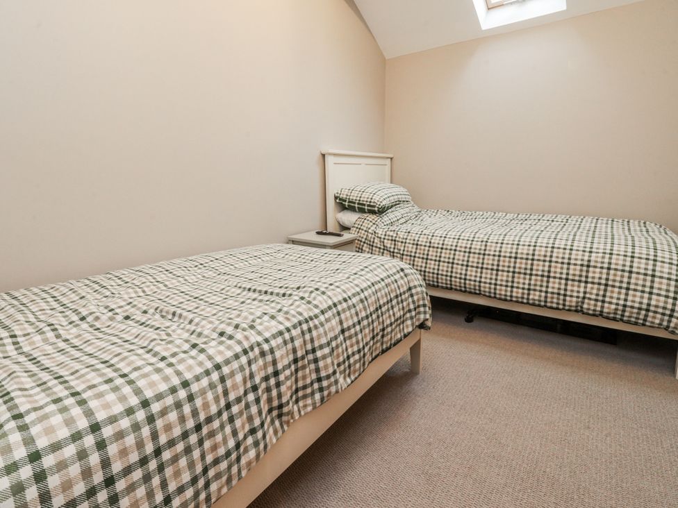 A bedroom with two beds and a skylight at Henside Cottage Settle