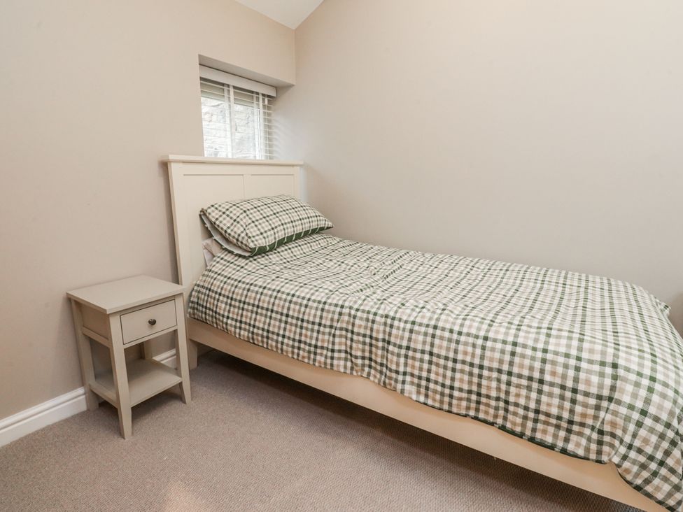 A bedroom with a single bed and bedside table at Henside Cottage Settle