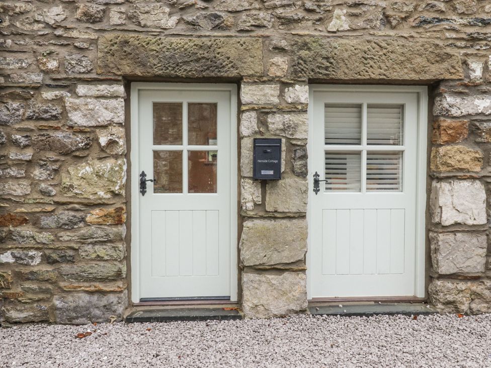 Two doors and a letterbox on a stone wall at Henside Cottage Settle