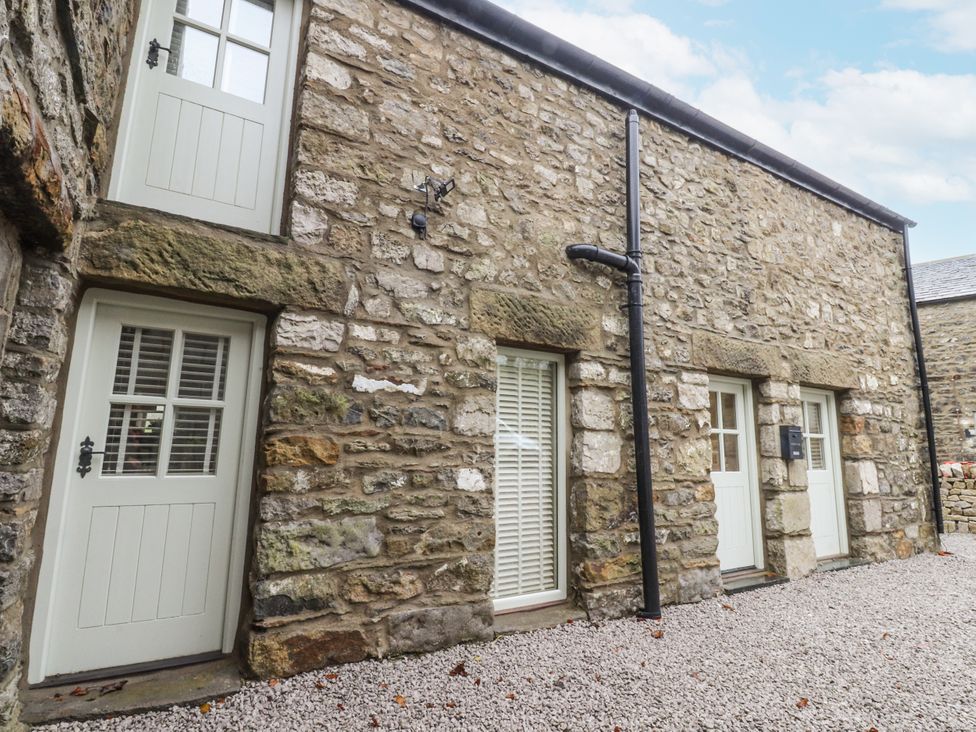Exterior view of a stone building with doors and windows at Henside Cottage in Settle