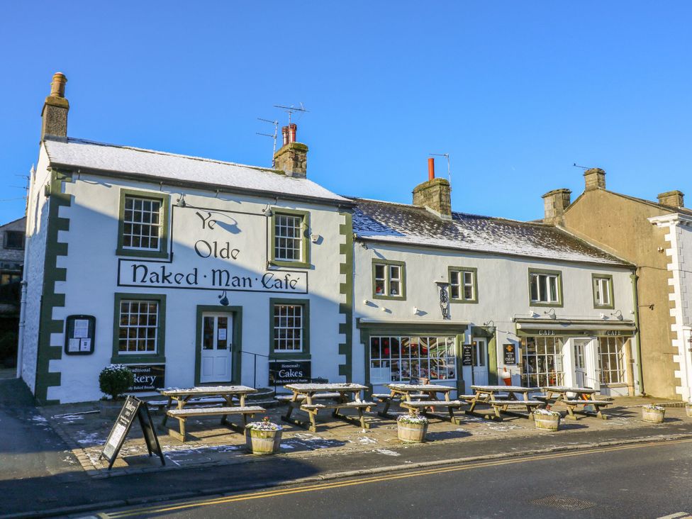 An outdoor cafe with tables and chairs at Ye Olde Naked Man Cafe in Langcliffe near Settle