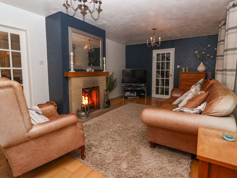 A living room with a fireplace and sofa at Lair Close House in Harrogate