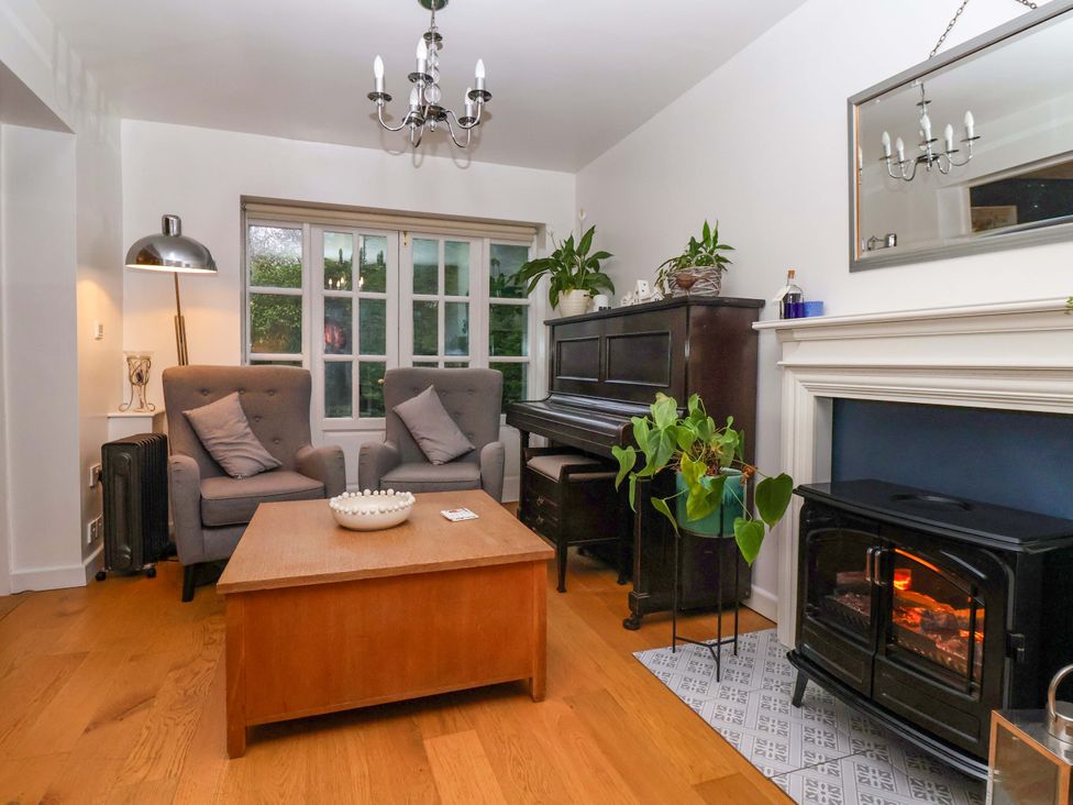 A living room with armchairs and a piano at Lair Close House in Harrogate