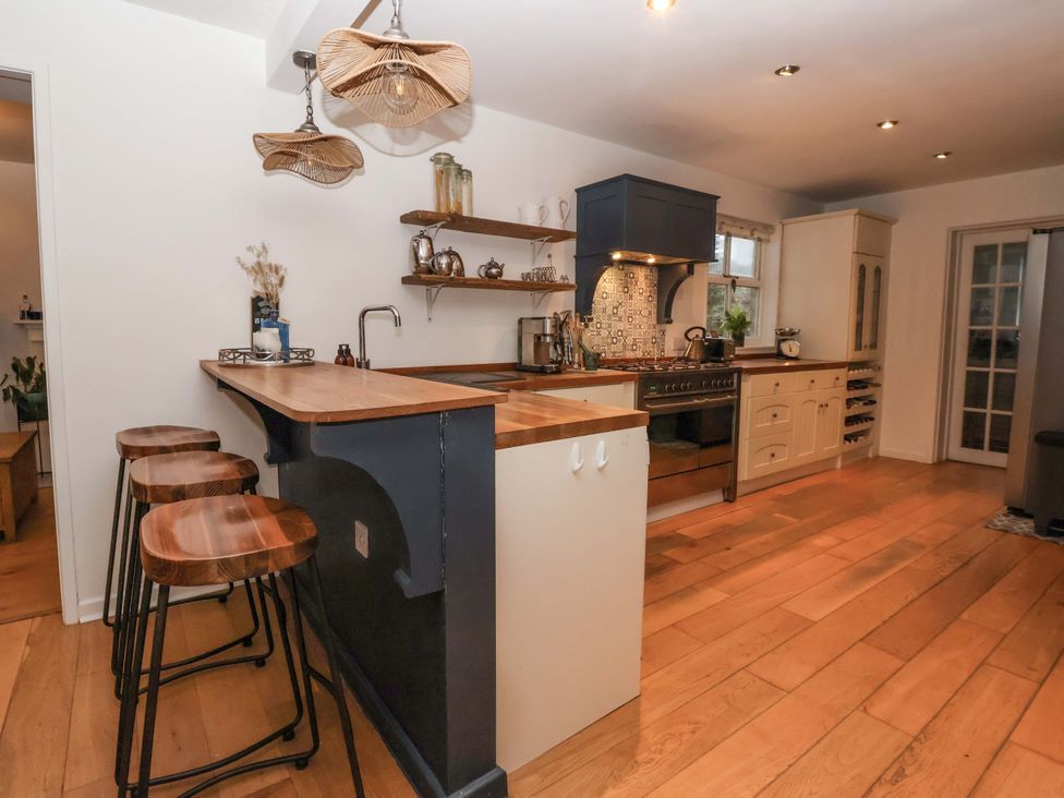 A kitchen with a kitchen island and bar stools at Lair Close House in Harrogate