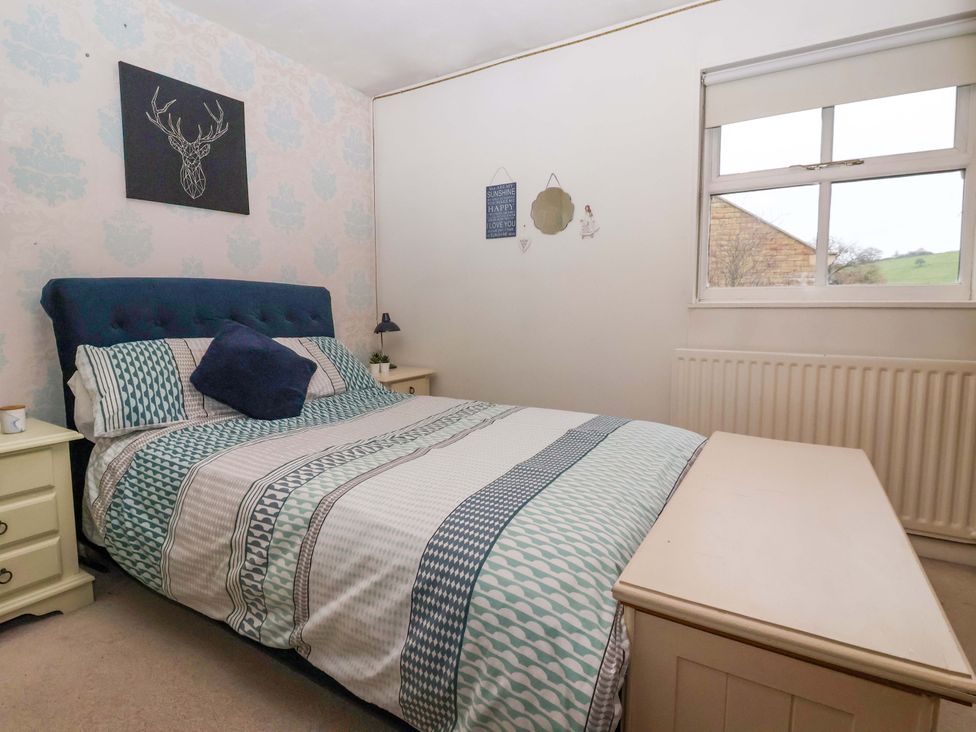 A bedroom with a bed and window at Lair Close House in Harrogate