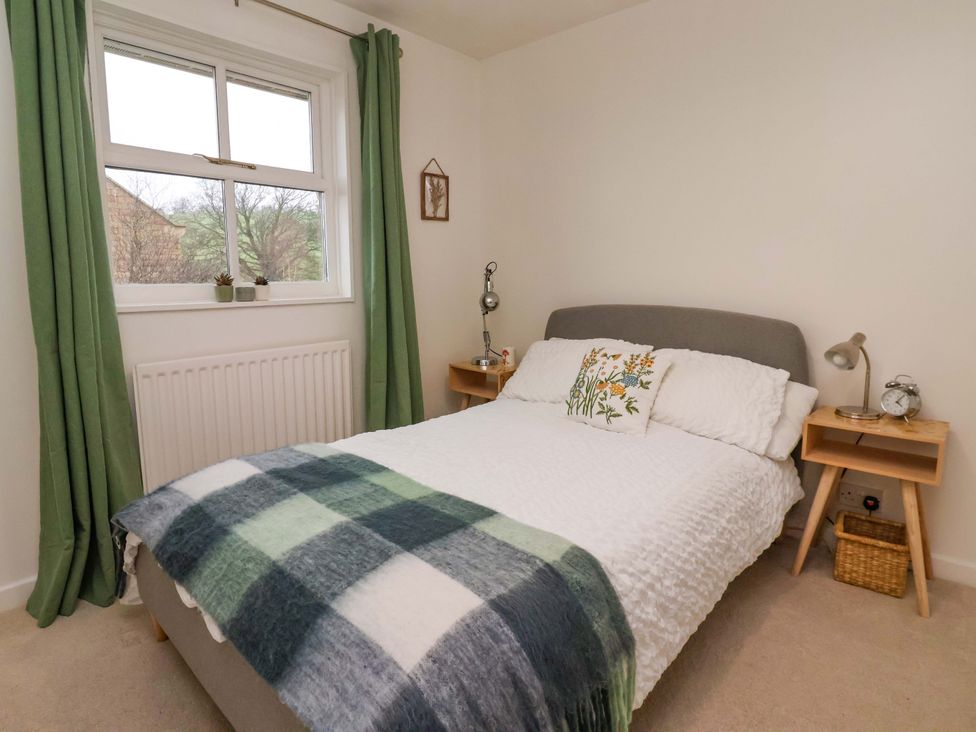 A bedroom with a bed and nightstands at Lair Close House in Harrogate