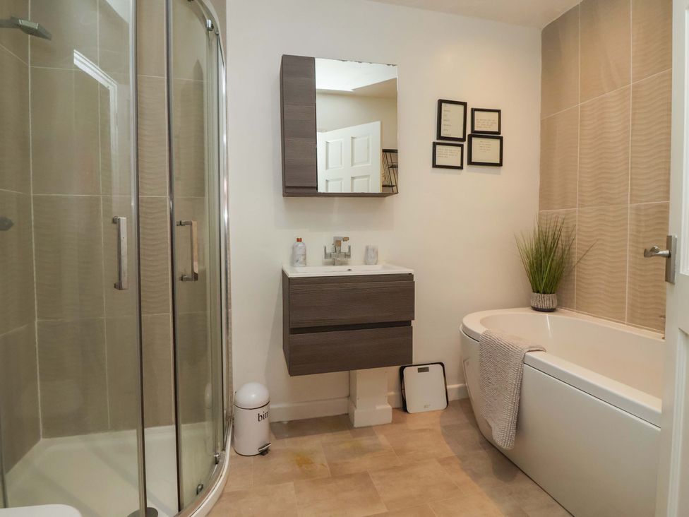 A bathroom with a shower, bathtub, and sink at Lair Close House Harrogate