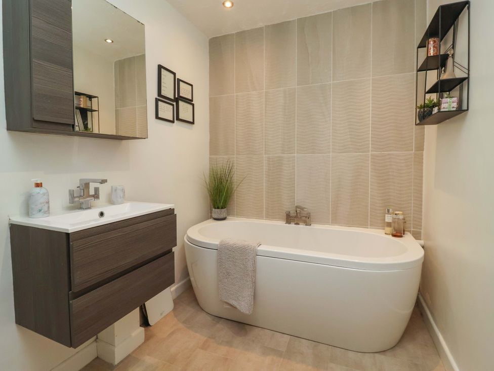 A bathroom with a bathtub and sink at Lair Close House in Harrogate