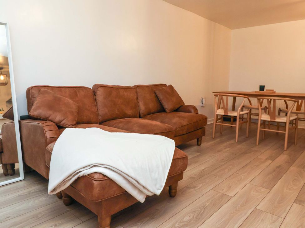 A living room with a sofa and a dining area at Apartment in Harrogate