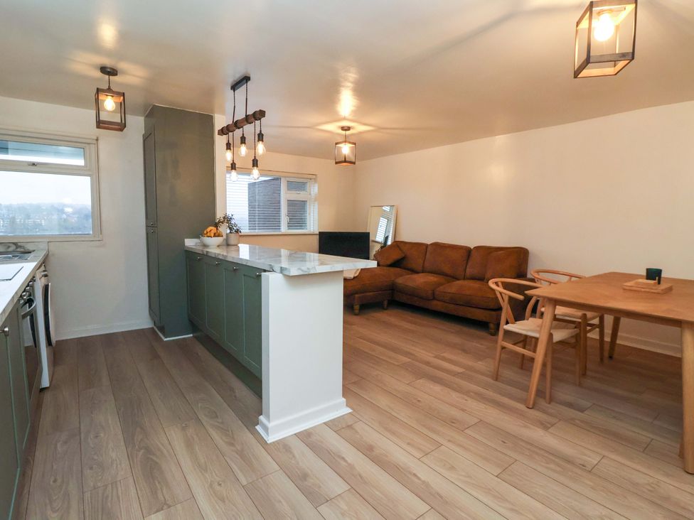 A kitchen and living room with a sofa and dining area in Apartment Harrogate