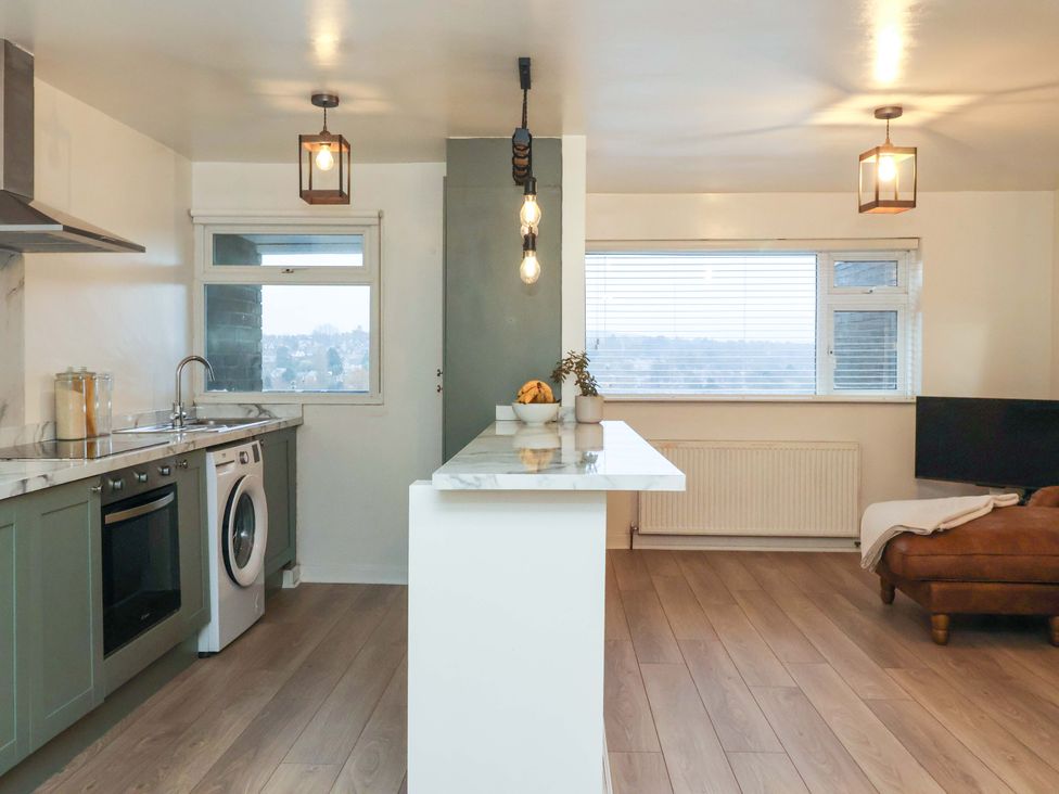 A kitchen with appliances and a living area at Apartment in Harrogate
