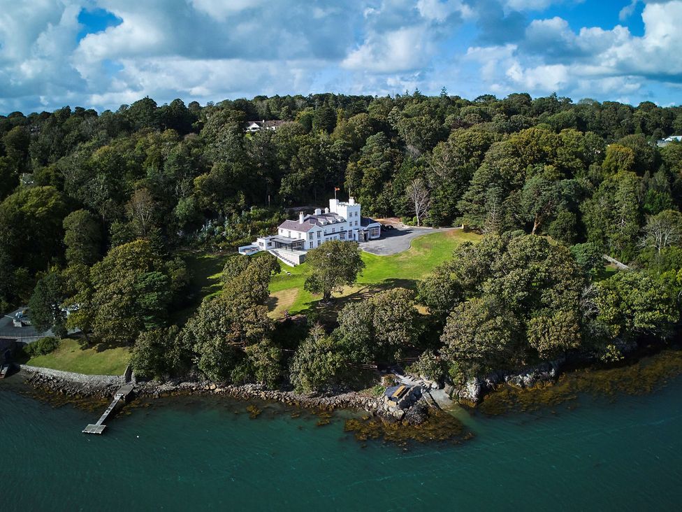 A large house surrounded by trees and water at Craig y Don in Glyngarth near Llandegfan