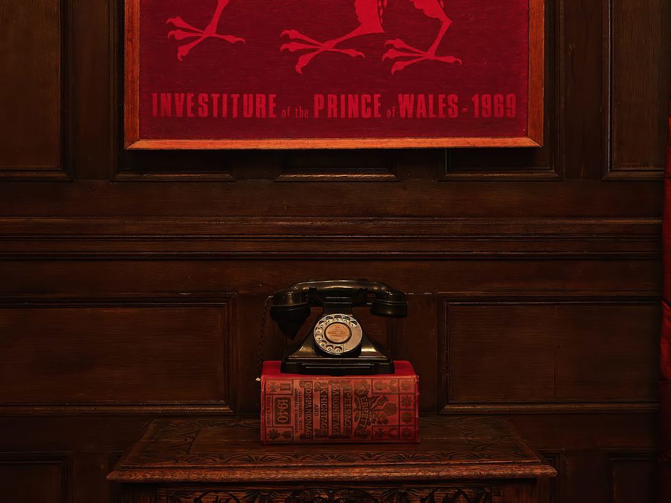 A telephone and books displayed on a cabinet at Craig y Don in Glyngarth near Llandegfan