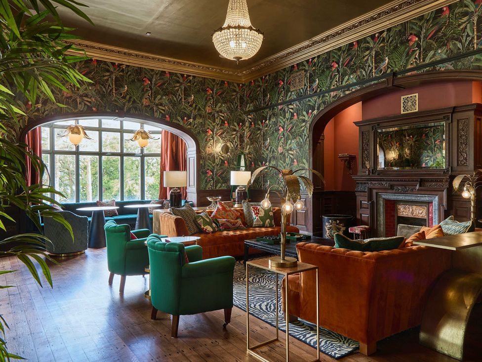 A living room with a fireplace and seating at Craig y Don in Glyngarth near Llandegfan