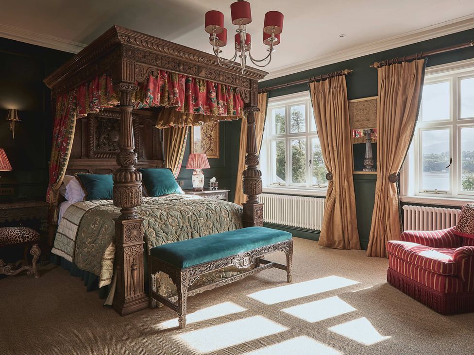 A bedroom with a four-poster bed and seating at Craig y Don in Glyngarth near Llandegfan