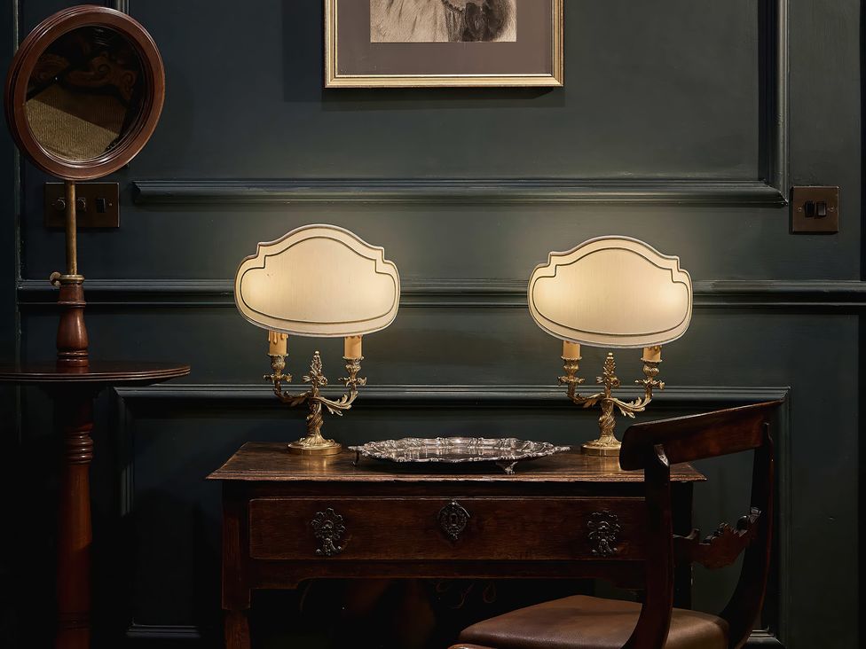 A table with lamps and a mirror at Craig y Don in Glyngarth near Llandegfan