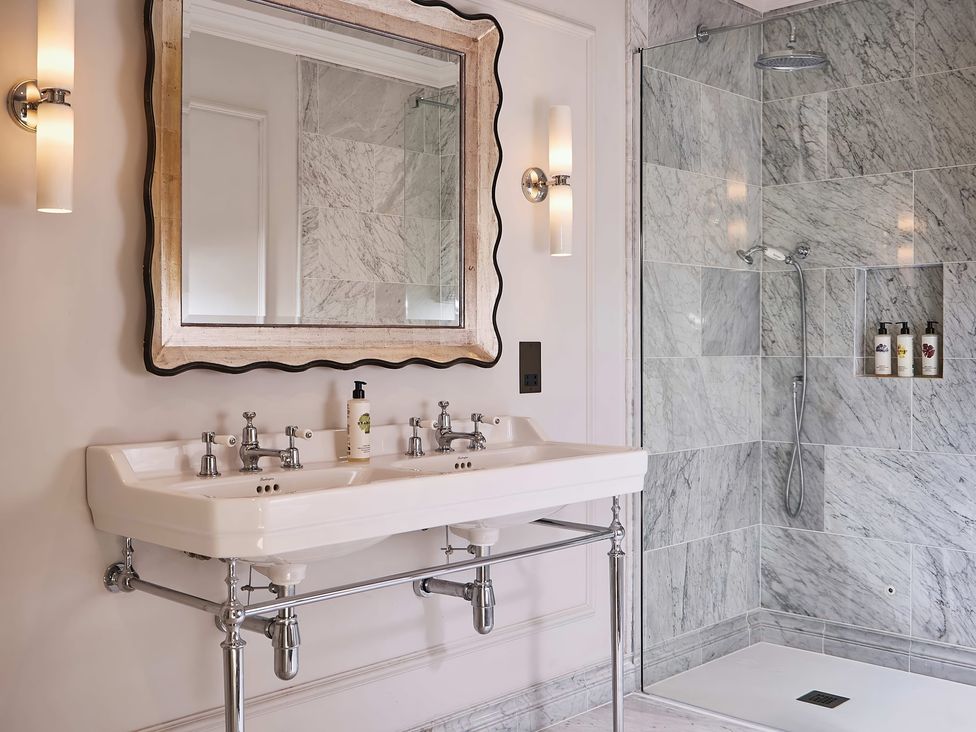 A bathroom with a double sink and shower at Craig y Don Glyngarth near Llandegfan