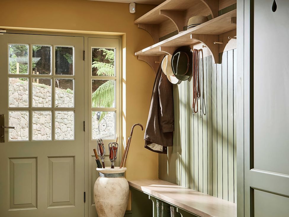 An entryway with a bench and coat hooks at Craig y Don Glyngarth near Llandegfan