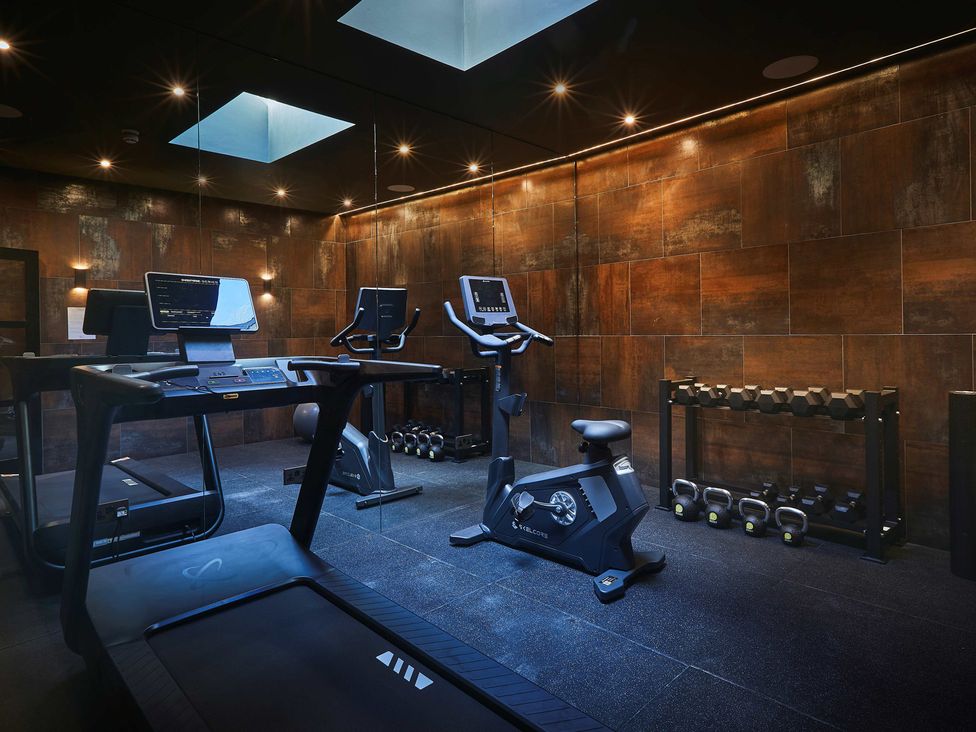 A gym with a treadmill and exercise bike at Craig y Don in Glyngarth near Llandegfan