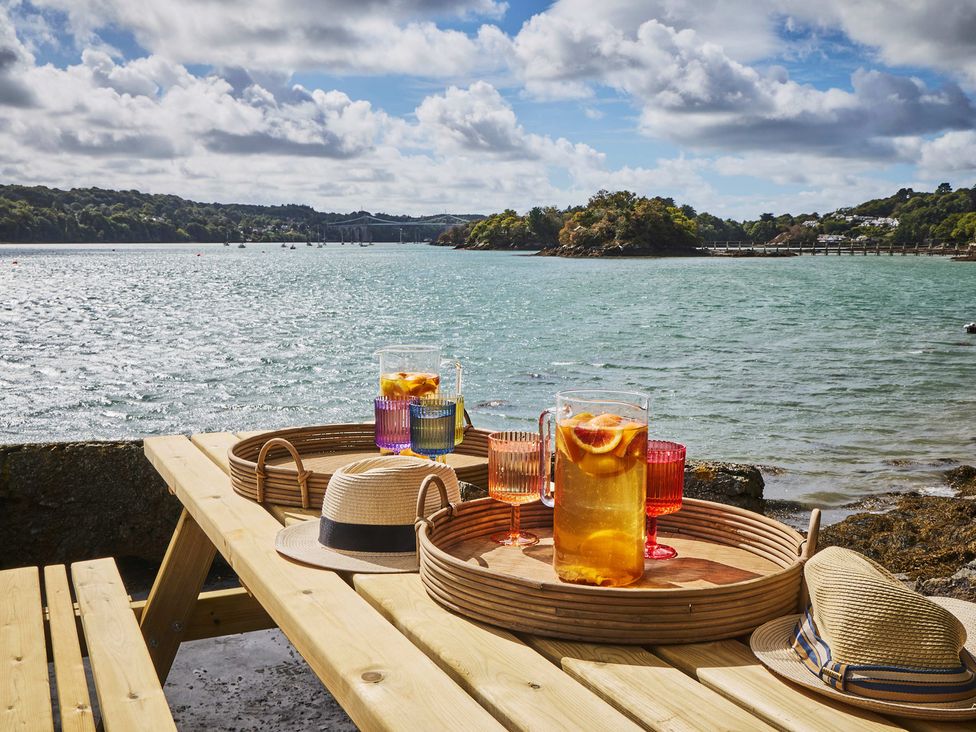 An outdoor table with drinks and hats at Craig y Don Glyngarth near Llandegfan