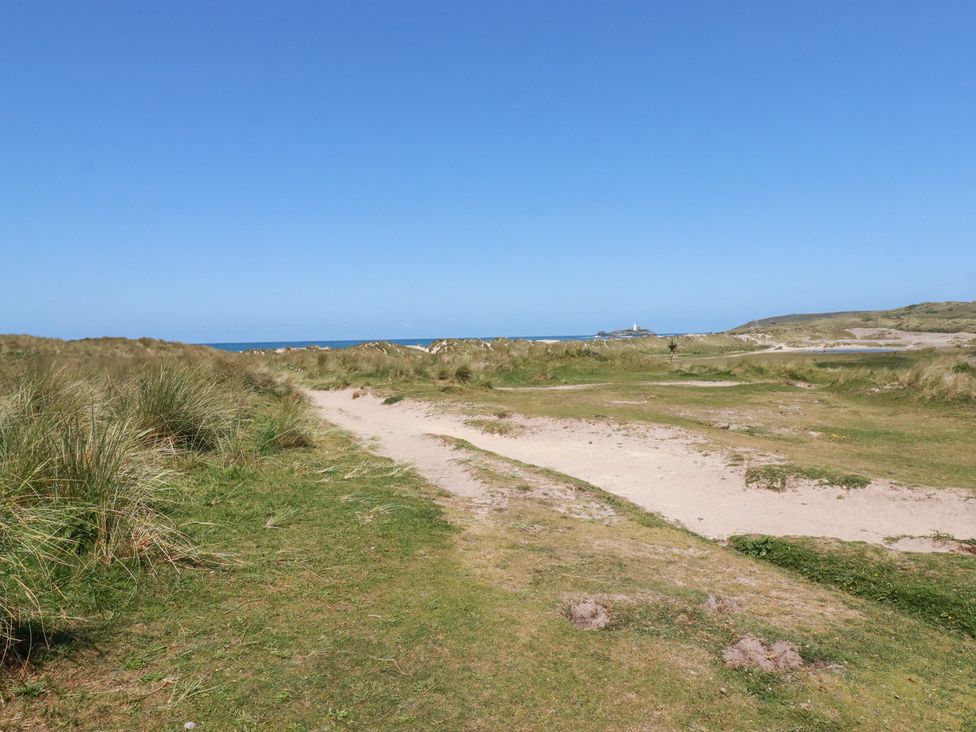 A sandy pathway leading to the ocean at Bramble Cottage in Gwithian near Connor Downs