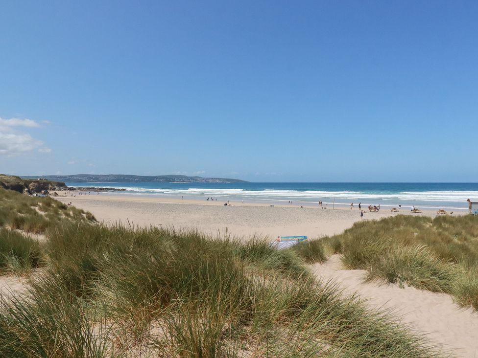 A beach view with grass and water at Bramble Cottage in Gwithian near Connor Downs