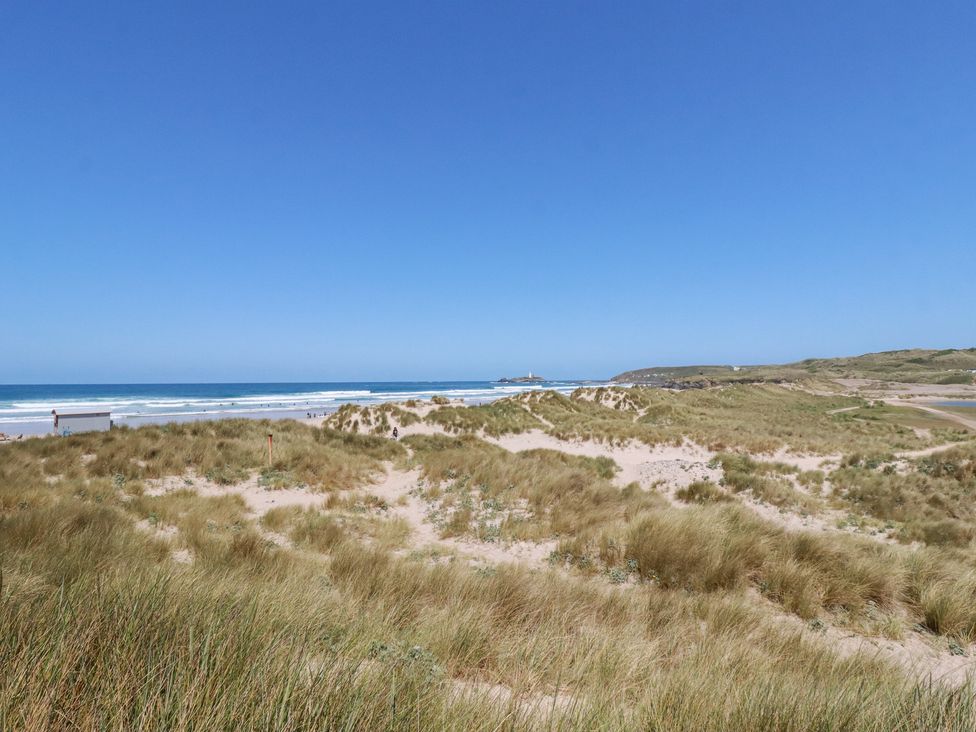 A beach with sand dunes and ocean view at Bramble Cottage in Gwithian near Connor Downs