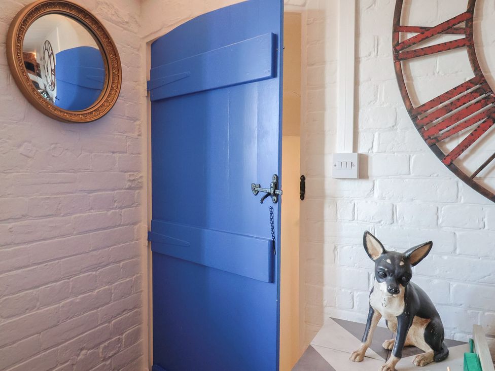 An entryway with a blue door and a dog statue at The Clock Tower in Rousdon, Nr Lyme Regis