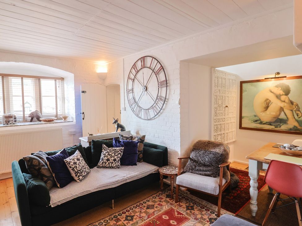 A living room with a sofa and armchair at The Clock Tower in Rousdon, Nr Lyme Regis