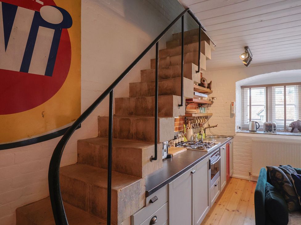 A kitchen with a staircase and kitchen appliances at The Clock Tower in Rousdon, Nr Lyme Regis
