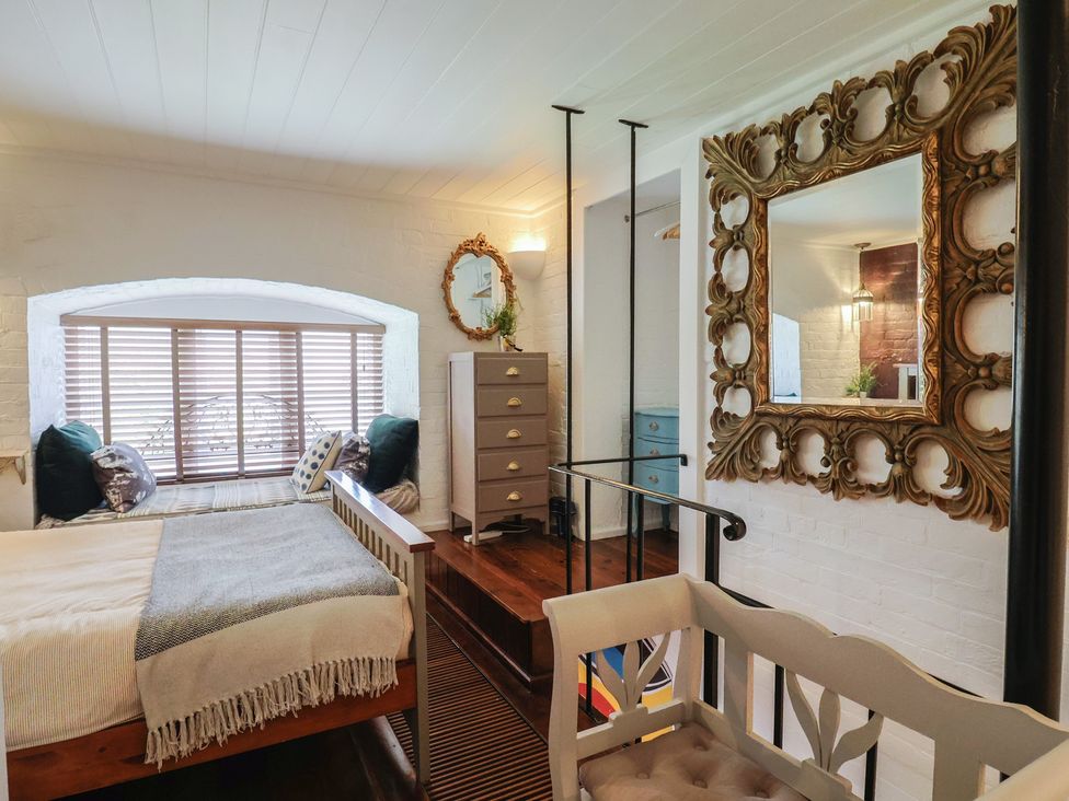 A bedroom with a bed and window seating at The Clock Tower in Rousdon, Nr Lyme Regis