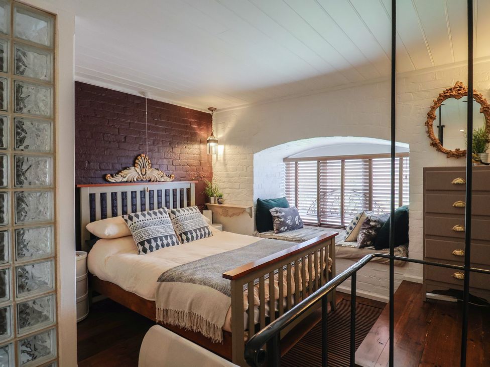 A bedroom with a bed and a window with blinds at The Clock Tower in Rousdon, Nr Lyme Regis