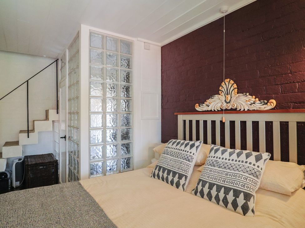 A bedroom with a bed and decorative headboard at The Clock Tower in Rousdon, Nr Lyme Regis