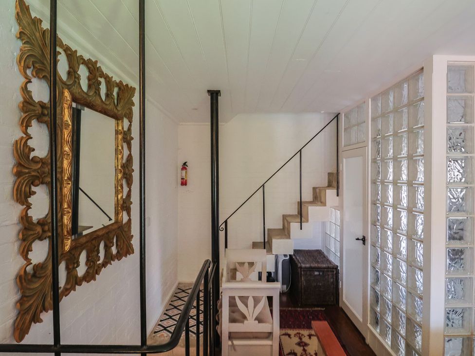 A hallway with a staircase and a glass block wall at The Clock Tower in Rousdon, Nr Lyme Regis