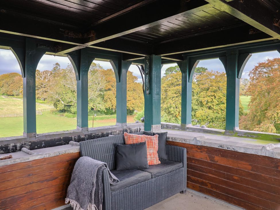 An outdoor seating area with a couch and pillows at The Clock Tower in Rousdon, Nr Lyme Regis