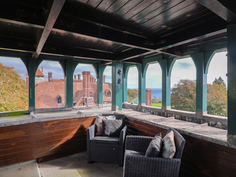 A balcony with chairs overlooking the sea at The Clock Tower in Rousdon, Nr Lyme Regis