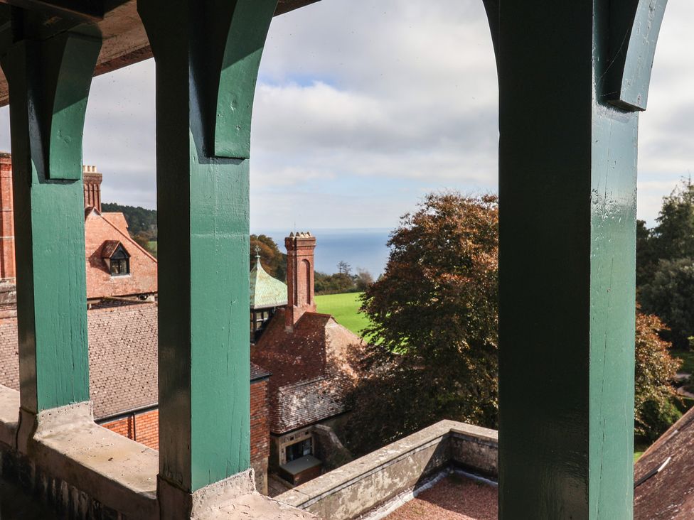 A view from a balcony showing rooftops and the sea at The Clock Tower Rousdon, Nr Lyme Regis