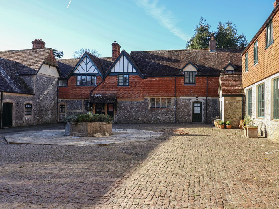 A courtyard with buildings and flower pots at The Clock Tower in Rousdon, Nr Lyme Regis