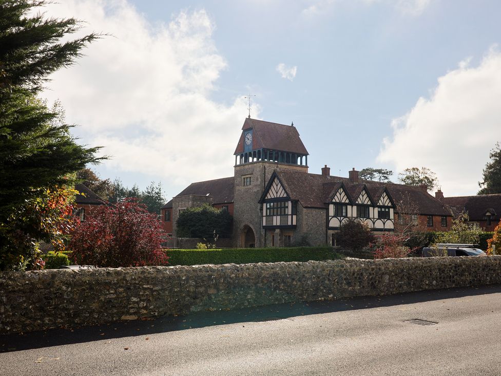 A building with a clock tower and surrounding greenery at The Clock Tower in Rousdon, Nr Lyme Regis