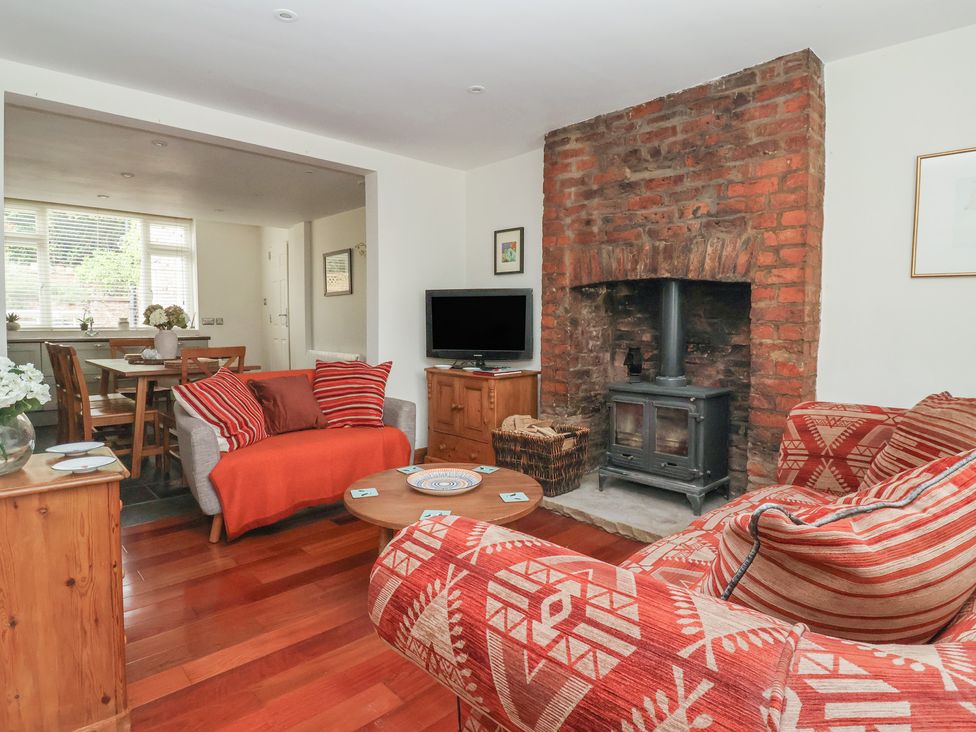 A living room with a fireplace and television at Pear Tree Cottage in Great Ouseburn